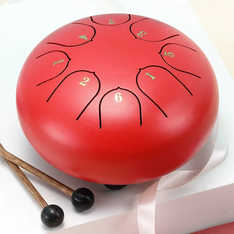 A bold, crimson red 6-inch 8-note steel tongue drum, a beautiful and vibrant percussion instrument.