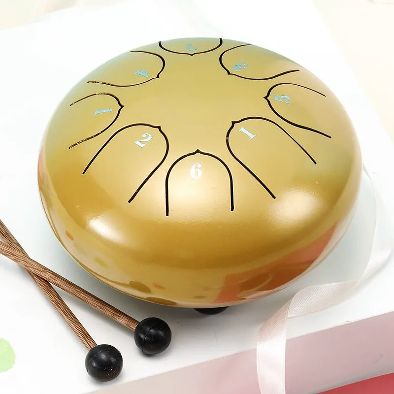 A radiant, sunburst gold 6-inch 8-note steel tongue drum, adding a touch of elegance to any space.