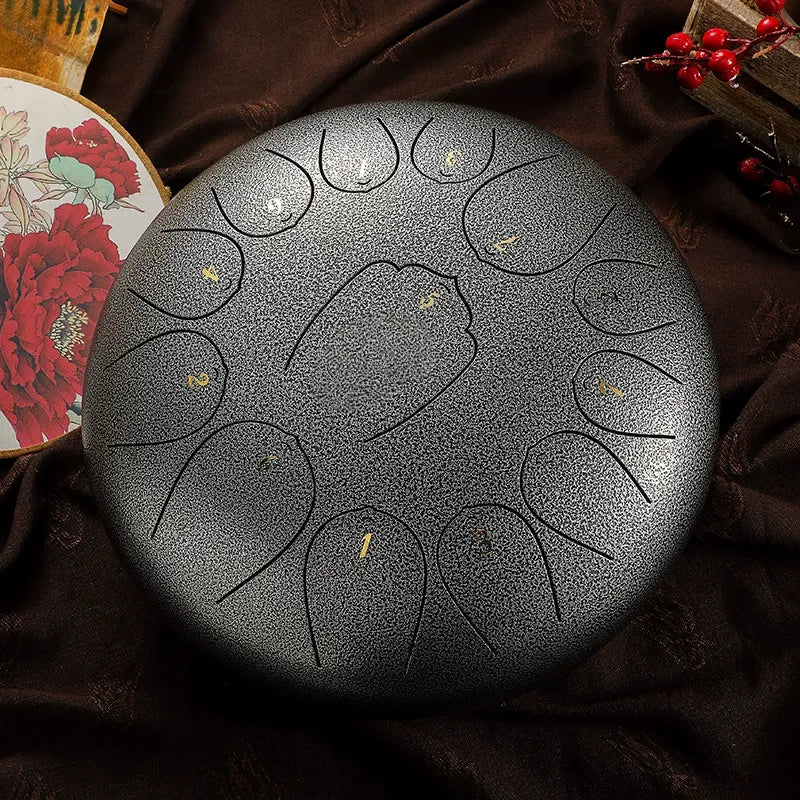 A shining, moonlight silver MoralGain 12-inch 13-note steel tongue drum, a sleek meditation musical instrument.