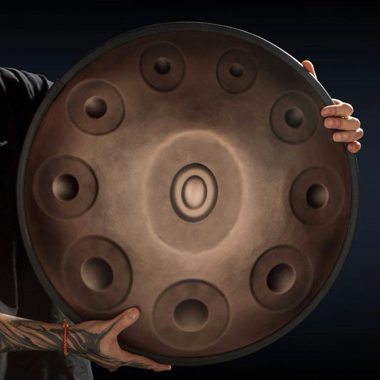 A player's hand gently touching the surface of the MoralGain® Master Patina Bronze handpan, emphasizing its warm and unique tactile feel.