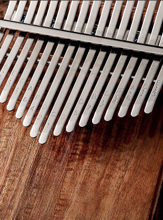 A detailed shot of the MoralGain® Pro kalimba's keys, highlighting the clear engraving of notes to assist beginners.