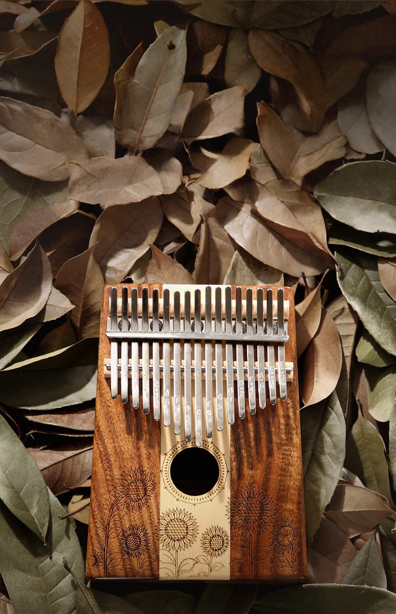 Close-up of the metal tines on a 17-key kalimba with engraved musical notes, ideal for beginners using tuning apps to ensure the frequency is set for a perfect meditative and healing sound.