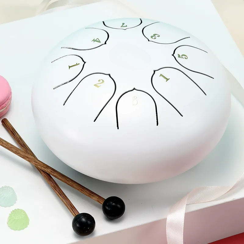 A serene, cloud-white 6-inch 8-note steel tongue drum, perfect for beginners and meditation.