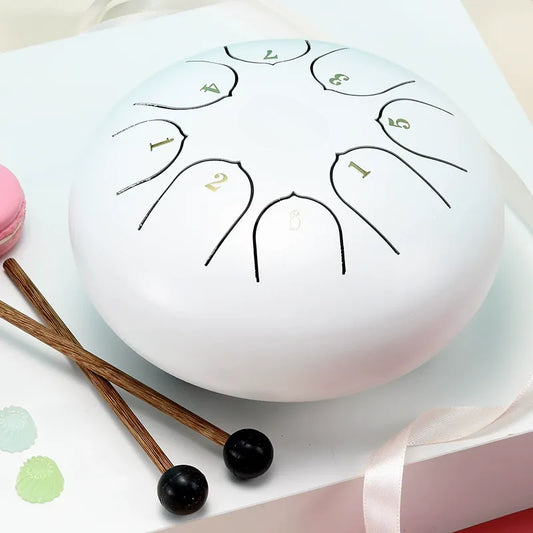A serene, cloud-white 6-inch 8-note steel tongue drum, perfect for beginners and meditation.