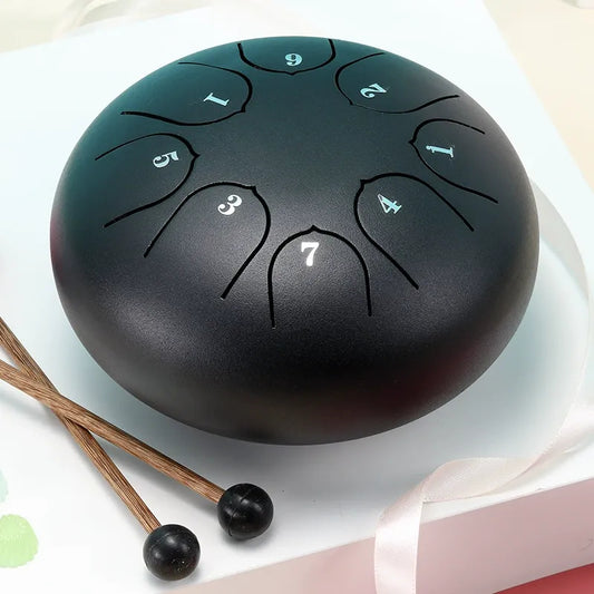 A sleek, matte black 6-inch 8-note steel tongue drum, ideal for creating calming and meditative tones.
