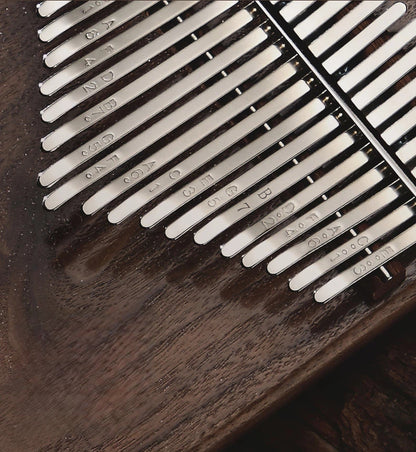 Close-up of a Grade-A solid wood kalimba featuring an ergonomic beveled slant-edge for comfortable grip and hand-polished walnut grain