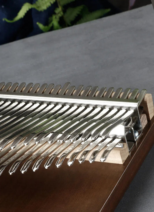 High-end 42-tone professional thumb piano with dual-layer steel keys and a solid black walnut body for extended resonance and chromatic musical performance.