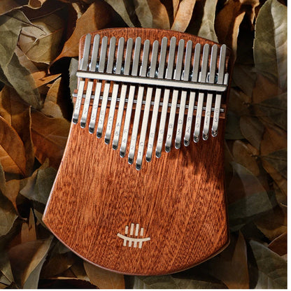 Close-up of an aesthetic wooden thumb piano in soft lighting, accented by a dried leaf, evoking a peaceful and healing atmosphere suitable for wellness gifts or meditation.