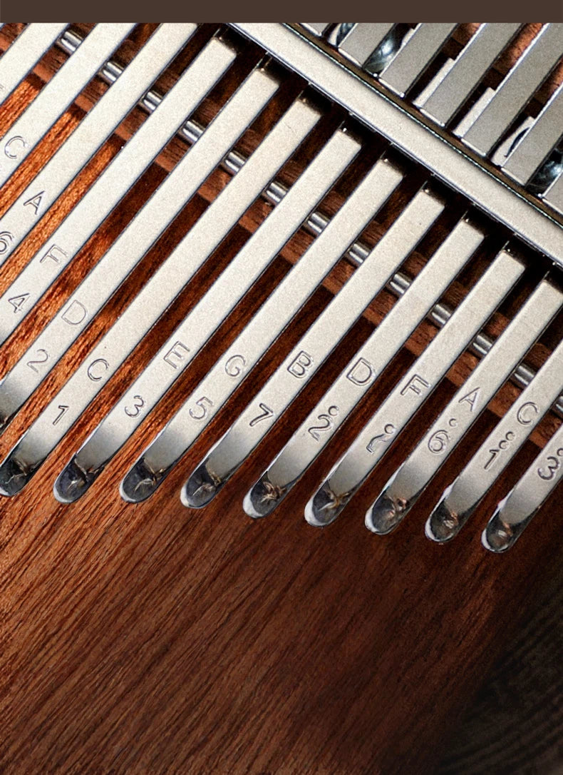 Top-down view of a handcrafted kalimba showing its ergonomic curved body, unique brand logo inlay, and neatly arranged metal keys labeled with musical notes and numbers.