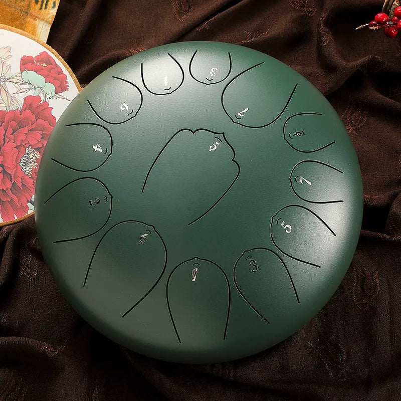 A calming, sage green MoralGain 12-inch 13-note steel tongue drum, a therapeutic handpan for sound baths.