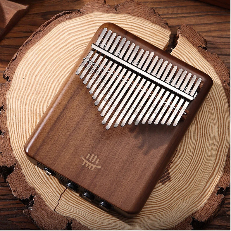 Close-up of a professional MoralGain® Electric Black Walnut Kalimba connected to an audio cable, featuring icons for its 5 built-in smart effect modes: Reverberation, Chorus, Delay, Reverb+Chorus, and Reverb+Delay.