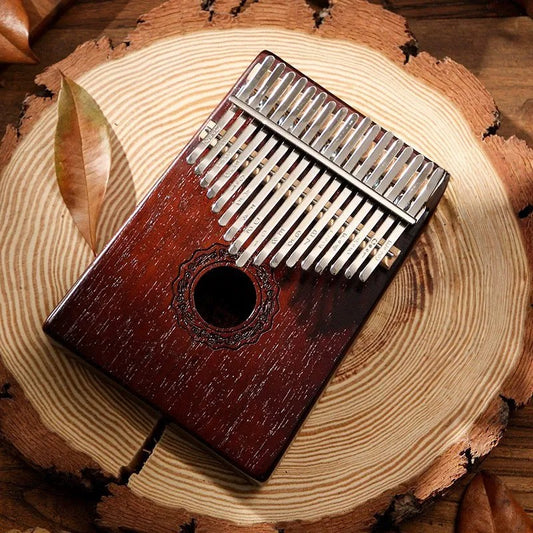 A close-up of the MoralGain® Pro kalimba, showcasing the natural grain of its mahogany wood and the smooth vintage finish.