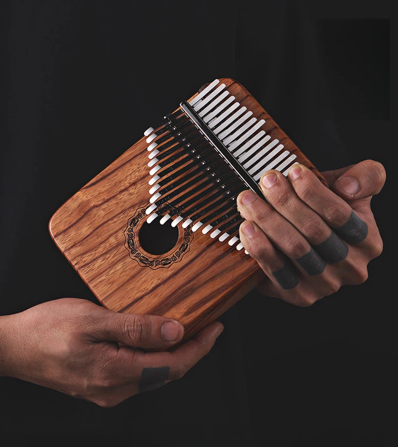 Close-up of a 21-key hollow-body kalimba with professional manganese steel tines and a hand-polished Gaboon Rosewood resonant box, ideal for intermediate players and sound therapy.